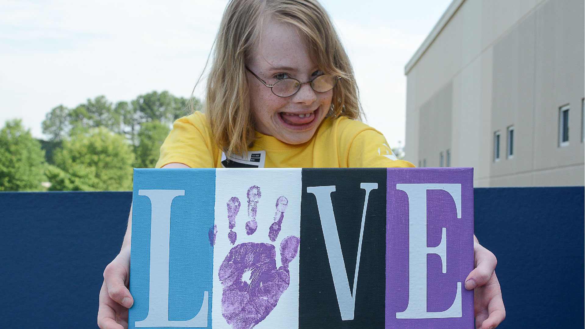 Special Needs member holds up a picture that says Love at Brookwood Church